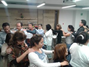 People giving each other shoulder massages in a group setting.